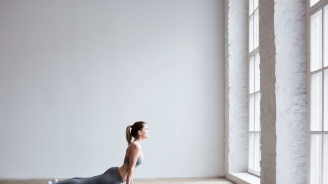 Woman exercising yoga indoors.