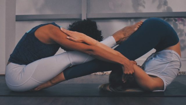 Two women doing yoga exercises excercises