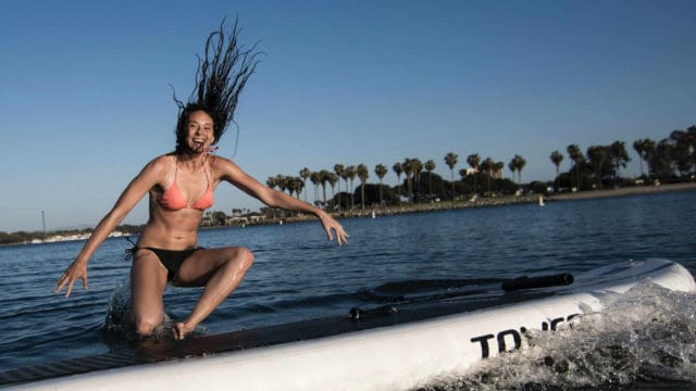Women is jumping from a board into the fresh water