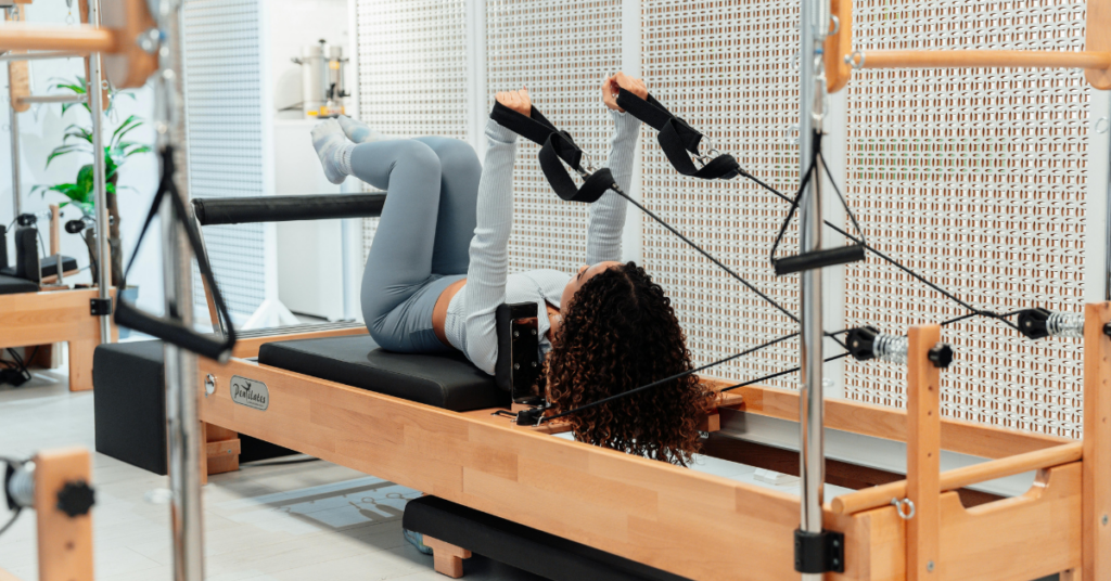 Frau auf dem Pilates Reformer